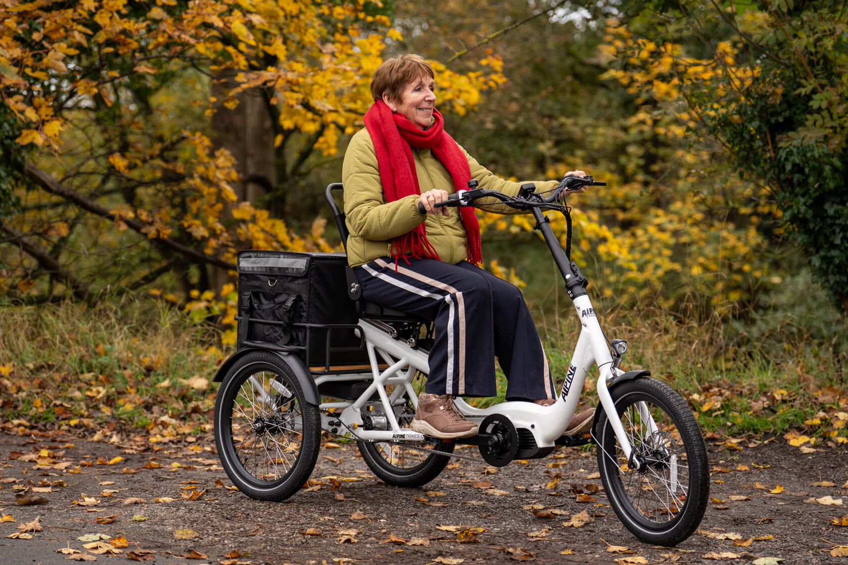 Woman riding a tricycle in an autumnal park