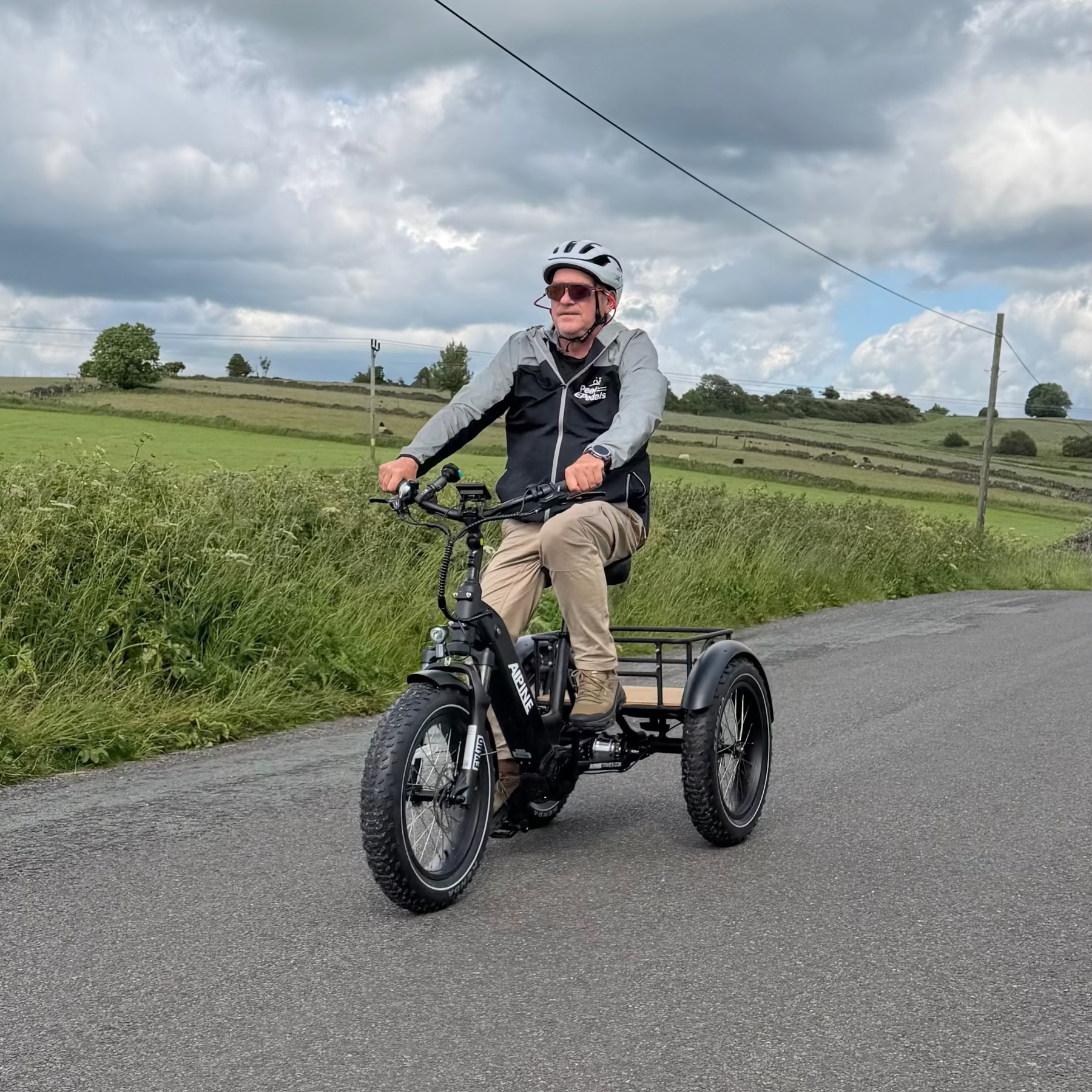 Man riding a tricycle on a road with a scenic background