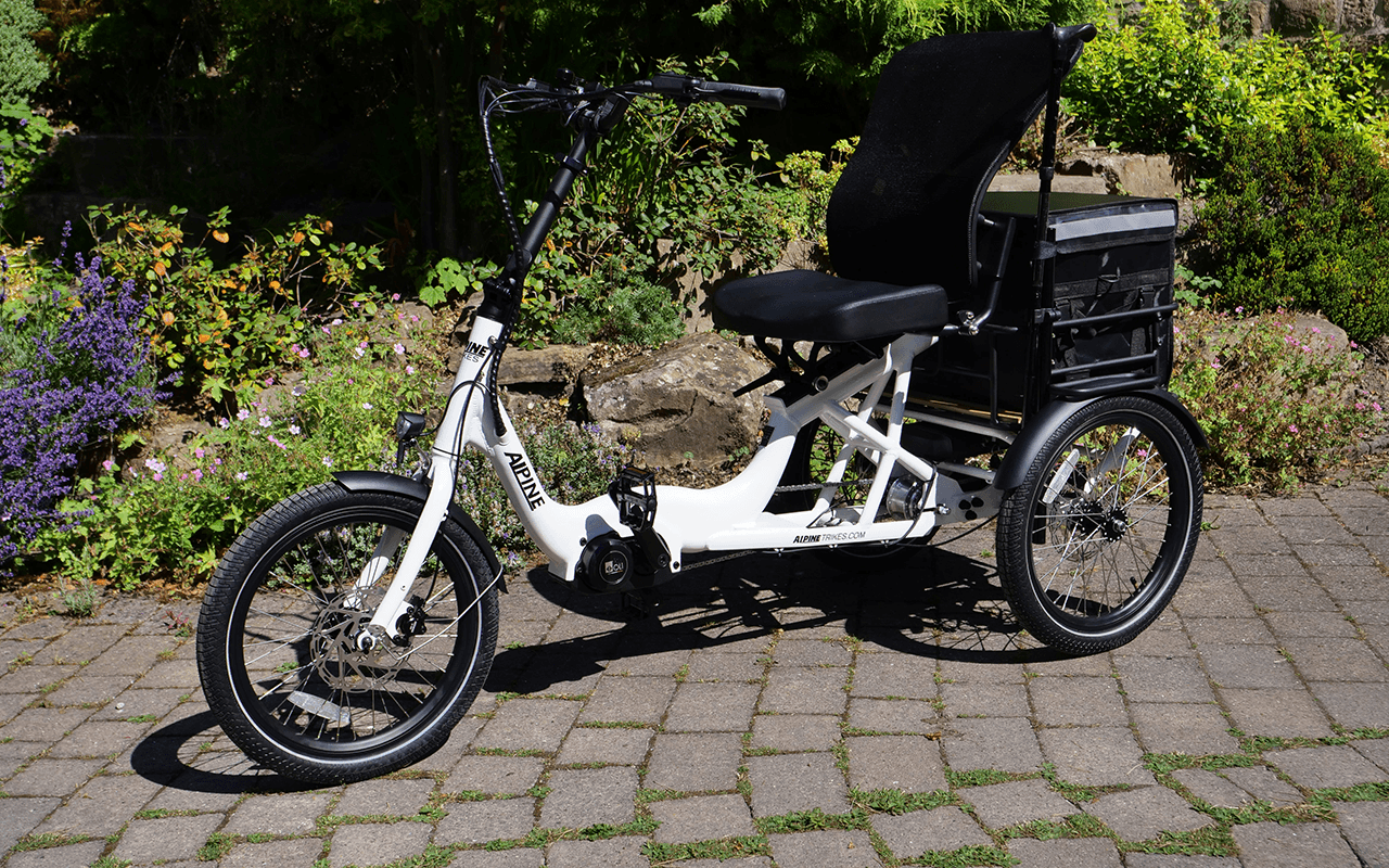 A white and black three-wheeled tricycle with a rear cargo box and walking stick holder.